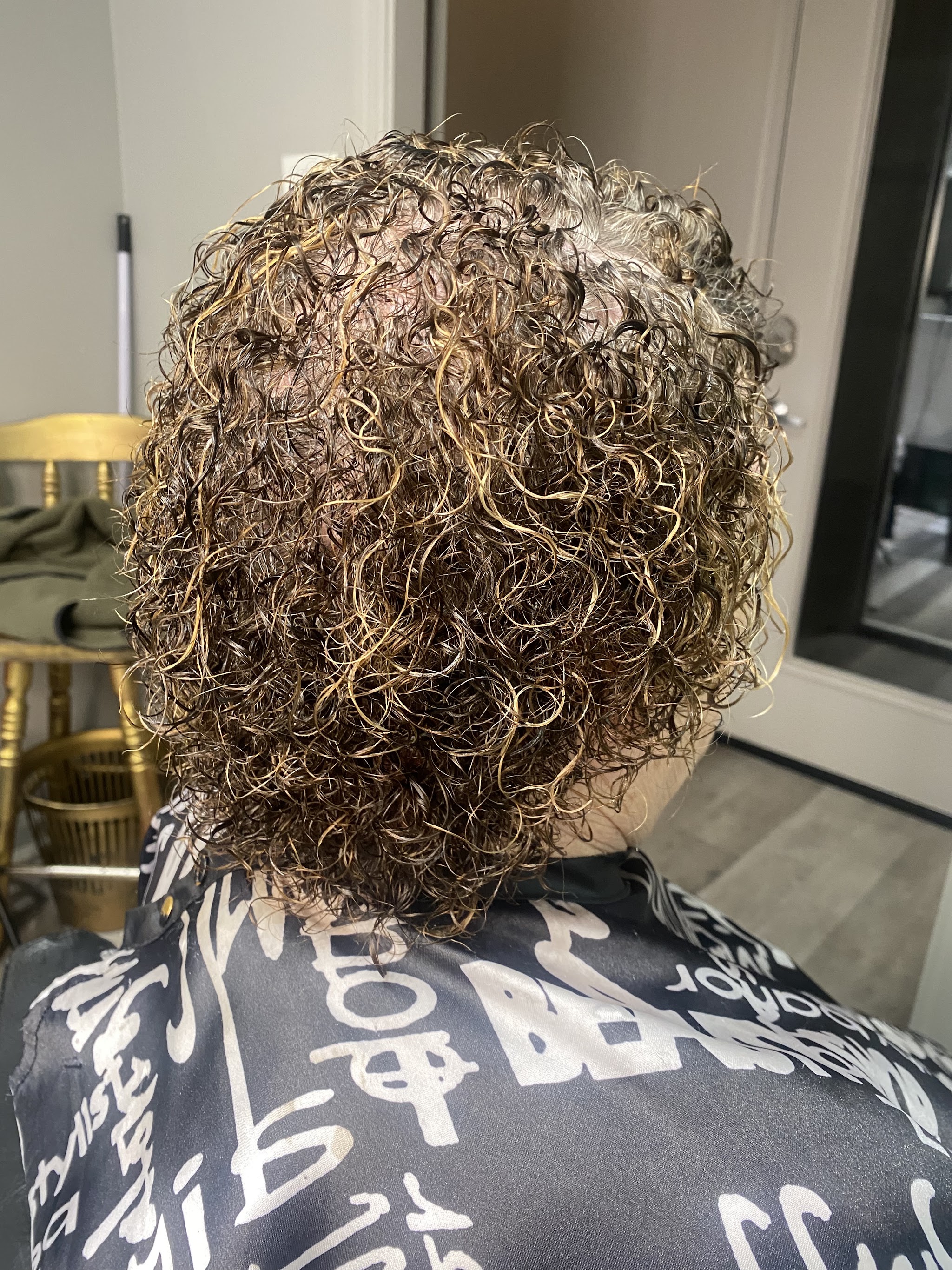 Tight curly perm with golden highlights